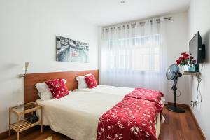 波尔图弗兰克尼情人公寓的一间卧室配有一张带红色枕头的大床