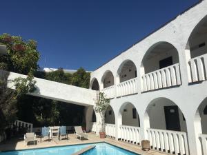 乔卢拉Hotel Calli Quetzalcoatl的一个带游泳池的庭院和一座白色的建筑