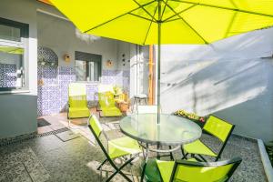 波尔图花园大道公寓的天井上配有带黄伞的桌椅