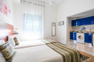 波尔图花园大道公寓的一间卧室配有两张带蓝色橱柜的床。