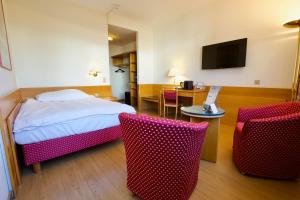 锡永罗纳酒店的酒店客房带一张床、一张桌子和椅子