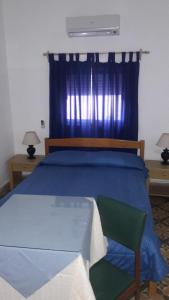 皮里亚波利斯Edificio Sagasti的一间卧室配有蓝色的床和绿色椅子