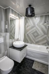 巴统Tina's Apartments with Panoramic Sea view的浴室配有盥洗盆、卫生间和浴缸。