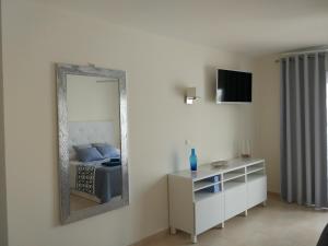 阿罗纳Los Cristianos studio, modern, spacious, pool,WiFi的一间设有镜子、一张床和梳妆台的房间