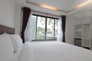 清迈古斯特之家酒店的卧室设有白色的床和大窗户