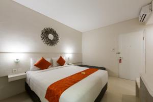 坎古The Rinaya Canggu by ecommerceloka的卧室配有带橙色枕头的大型白色床
