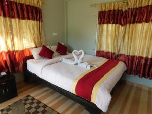 博卡拉丰收圆月乡村民宿的一间卧室配有一张大床和毛巾