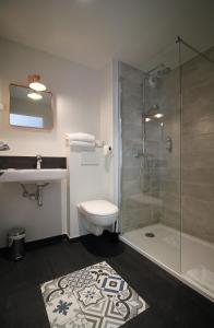 凯恩福恩塔尼卡昂中心酒店的带淋浴、卫生间和盥洗盆的浴室