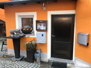 Zell im Fichtelgebirge华德斯坦旅馆的一座带黑色门的橙色墙的建筑