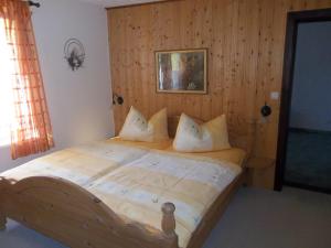 HausenFerienwohnung Günschmann的卧室内的一张带枕头的木床