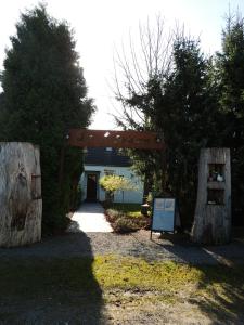 DochampsAuberge "La Fourchette Paysanne"的带有标志和树木的建筑物入口