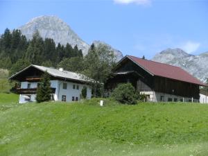 滕嫩山麓圣马丁欧贝哈瑞霍夫酒店的山丘上以山为背景的房子