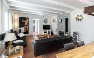 佩德雷尔Villa Montesolana的客厅配有黑色沙发和桌子