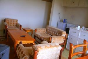 KakamegaSheywe Hotel Kakamega的一间带桌椅的客厅和一间厨房