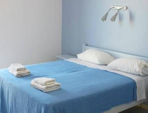 派尔季卡Alvi Studios的一间卧室配有蓝色的床和毛巾