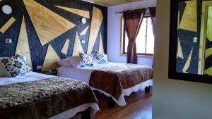 利纳雷斯Residencial del Maule的一间卧室设有两张床,墙上装饰有绘画作品