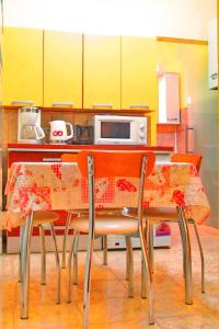 锡吉什瓦拉Citadel Park Apartment的厨房配有桌椅和黄色橱柜
