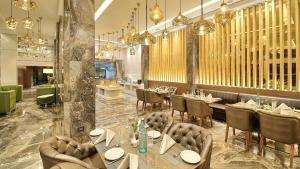 斋浦尔斋浦尔金色郁金香精华酒店的餐厅设有桌椅和吊灯。
