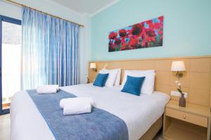 卡马利阳光大饭店 的酒店客房带两张带蓝白色枕头的床