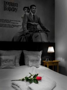 罗兹彼得库夫电影室公寓式酒店的一张黑白相间的一张床上男人的照片