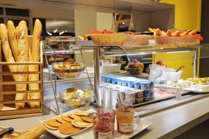 科尔马科尔马酒店 的面包店在柜台上供应面包和糕点
