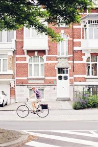 哈瑟尔特德斯鲁斯别墅住宿加早餐酒店的骑着自行车沿着街道的人