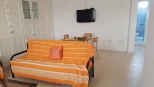 乌姆苏克Appartement à Houmt Souk Jerba的客房内的橙色沙发,红色枕头
