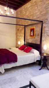卡塞雷斯Apartment Gloria的一间卧室配有一张带红色枕头的大床
