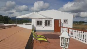 圣多美VIP House-Praia Francesca的甲板上配有遮阳伞的白色房子