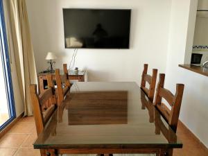 拉斯内格拉斯Apartamento Los Olivos的餐桌、椅子和墙上的电视