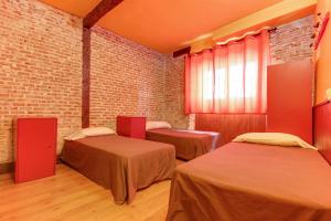 萨拉曼卡萨拉曼卡甜蜜之家旅馆的一间设有两张床和砖墙的房间