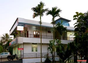 提喀迪Holiday Villa的一座白色的建筑,前面有棕榈树