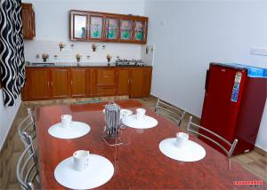 提喀迪Holiday Villa的厨房配有桌子和红色冰箱
