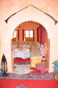 斯库拉Kasbah Elmehdaoui的一间带桌子的客厅和一间带桌子的房间