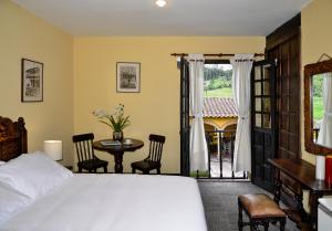 派帕Hotel Hacienda El Salitre的一间卧室配有一张床、一张桌子和一个窗户。