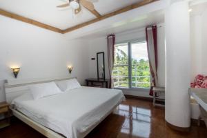 长滩岛Lanterna Hotel Boracay的卧室配有白色的床和窗户。