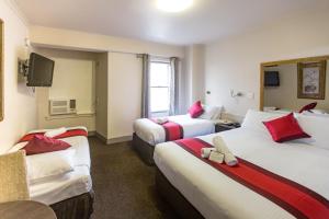 墨尔本城市广场汽车旅馆的酒店客房设有三张床和电视。