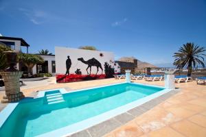 亚伊萨卡萨德希拉里奥酒店的一座游泳池,位于一个院子里,上面画着骆驼