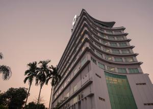 仰光韦恩酒店的一座高大的建筑,前面有棕榈树
