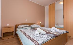 巴斯卡Apartments Kraljić I的一间卧室配有一张带两个枕头和镜子的床
