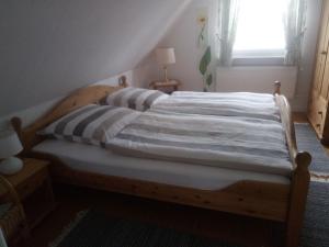 比德尔斯多夫Ferienwohnung Stanke的窗户客房内的木床