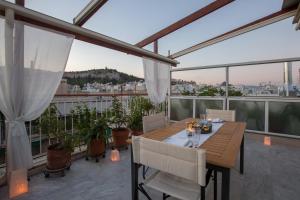 雅典Acropolis at your fingertips的阳台上的木桌和椅子