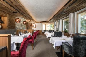 阿亨基希纳特尔-阿克提度假酒店的一间设有白色桌子和红色椅子的餐厅