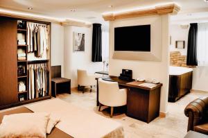 曼杜里亚BHB Hotel的客厅配有书桌和电视。