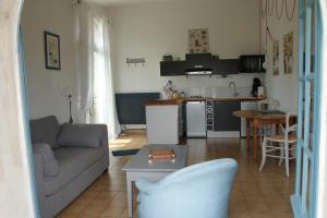 MontmaurLa Bleuette的带沙发的客厅和厨房