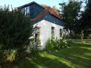 伊尔德帕特斯伍德Voorhuis的一座白色的小房子,设有绿色屋顶