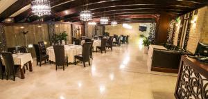 萨图马雷Hotel Aramia的用餐室配有桌椅和吊灯。
