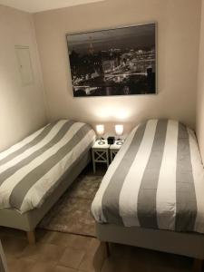 尼乌波特Marie-Alice的一间卧室设有两张床,墙上配有电视。