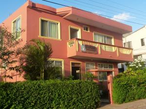 巴克里索莫雷诺港特利托宾馆的粉红色的房子设有阳台和灌木丛