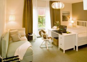 伊塞尔恩哈根奥斯彩特酒店的一间卧室配有一张床和一张带笔记本电脑的书桌